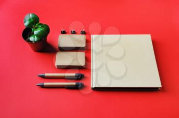Blank kraft corporate stationery set on red paper background. Corporate identity template. Responsive design mockup.
