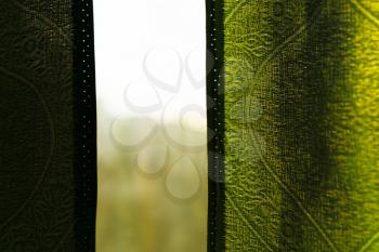 View through window with green curtains background