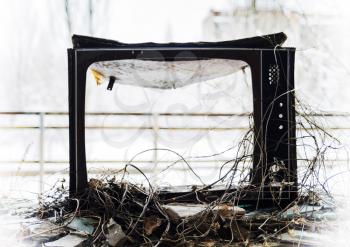 Horizontal vintage broken tvset in radioactive pripyat bokeh background