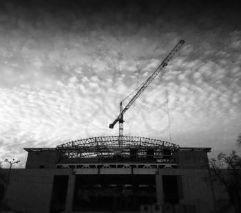 Building crane below fleecy clouds background hd