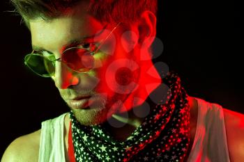 Fashion Art Photo of Handsome Young Man in the Light Colored Spotlights.