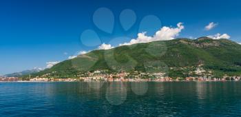 Small tourist villages on the Bay of Kotor in Montenegro, in a sunny summer day. The beginning of the cruise from Tivat city.