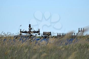 Oil well in the thickets of dry reeds. Oil well equipment.