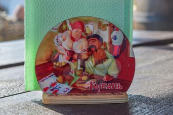 Russia, Ataman - 26 September 2015: Stand for napkins with painted Cossack and a Cossack woman. A man looks the woman in the neck and becomes happy.