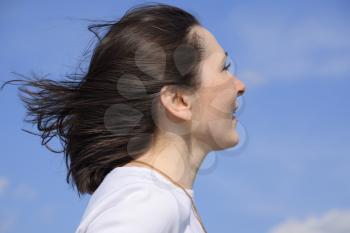Girl in a white sweater on a blue sky background