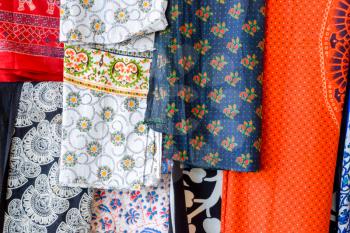 Indian fabrics hanging on the counter. Trade in fabrics from india. Fabric with patterns and patterns.