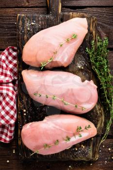 Raw chicken meat fillet on wooden background top view