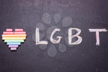 The heart of the colors of the rainbow and the word LGBT is written in chalk. 