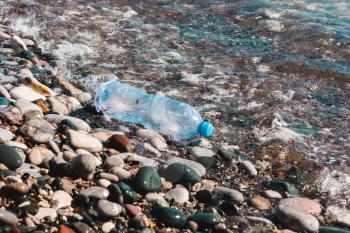 Plastic bottle on the beach, on the beach. Concept of pollution of the environment, ocean, sea, nature. Save the planet.