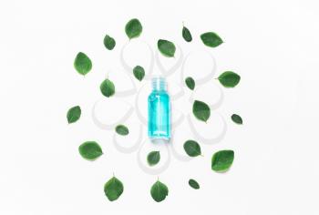 Bottle of sanitizer, hand gel with leaves on a blue background