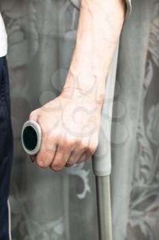 Senior woman's hand with crutch, cane. Concept of old age, pension, pensioner illness