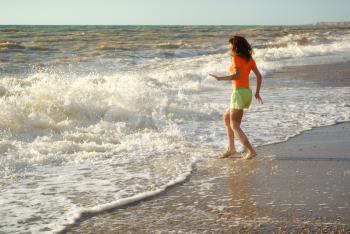Girl play on the beach. Emotional scene.