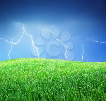 Lightning and green meadow. Nature composition.