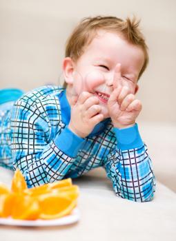 Portrait of a happy little boy with orange