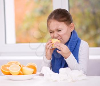 Little girl tries to taste a slice of orange