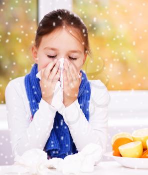 Cute girl is blowing her nose, over snowy background