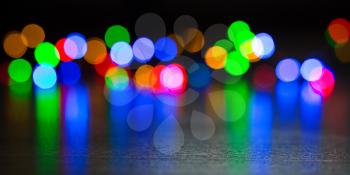 Festive defocused lights on a black background. Abstract background with glow