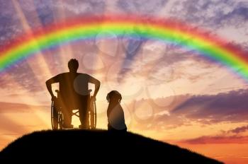 Disability. A disabled person in a wheelchair next to his dog at sunset and rainbow background
