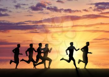 Running sports. Competition athletes runners on the sunset background