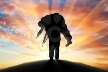 War and conflict concept. Soldier carries a wounded soldier at sunset