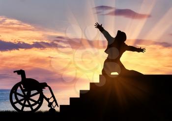 Concept of disability and positive. Silhouette of disabled person to experience happiness at the top of the stairs at sunset