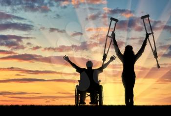 Happy people with disabilities in wheelchair and on crutches sunset. Concept happy disabled