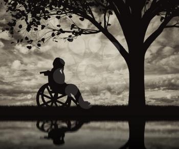 Disabled child in a wheelchair crying near tree on beach and reflection. Concept disabled child