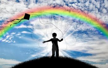 Silhouette child playing with kite on street day and rainbow. Concept childhood and happiness