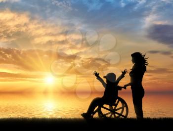 Happy boy in wheelchair and nurse sea sunset. Happy disabled child concept