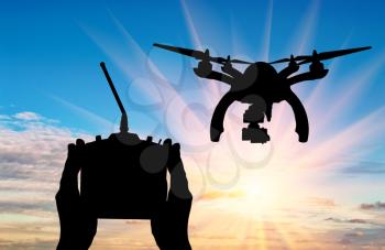 Silhouette flying drones and hands with remote control outdoors. Concept quadrocopters