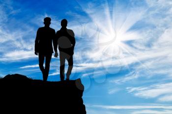 Silhouette of two gay men walking holding hands on top