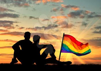 The concept of gay people. Silhouette of a pair of gay tourists on the nature and the rainbow flag
