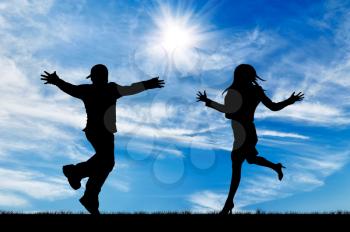 Concept of emotion. Silhouette of running to meet the man and woman on the background of the sunny sky