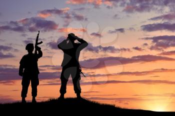 Silhouette of two soldiers on exploration at sunset