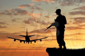 Silhouette of a soldier and an airplane at sunset