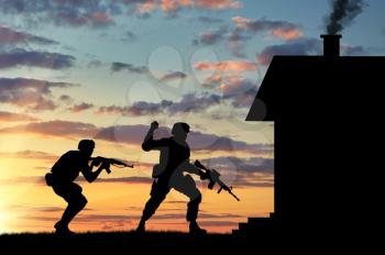 Concept of war. Silhouette of a soldier on the exploration front of the house at sunset