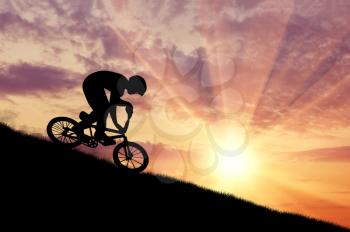 Concept of extreme sports. Silhouette of a cyclist moving at sunset