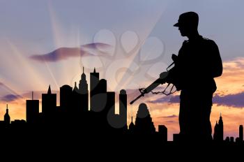 Concept of war and crisis. Silhouette of military weapons against the evening city