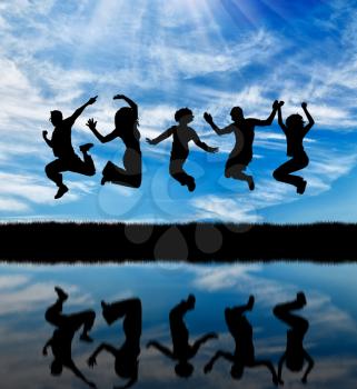 Concept of emotion. Silhouette of a happy group of people jumping against the sky