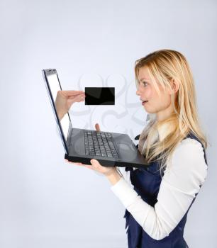 Concept services and advertising. Surprised woman holding a laptop and hand with business card