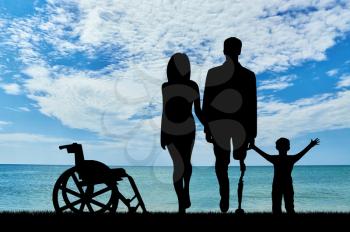 concept of rehabilitation of invalids with prosthetic legs. Disabled man with a family and wheelchair near sea