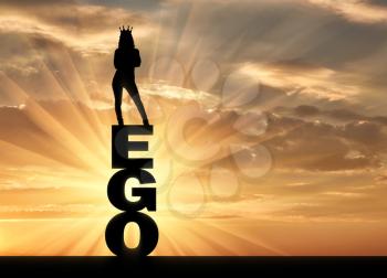 Silhouette of a narcissistic and selfish woman with a crown on her head standing on the word ego. The concept of narcissism and selfishness