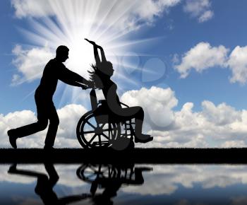 A fun time for a healthy man and a disabled woman in a wheelchair by the river. The concept of leisure for people with disabilities