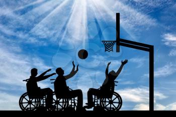 Three disabled to play wheelchair basketball outdoors. The concept of sports lifestyle people with disabilities