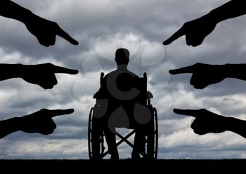 A disabled person in a wheelchair, people hands showing a finger at him. The concept of discrimination against people with disabilities