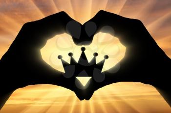 Hands of a man hold a crown, showing that he likes this symbol of the heart. The concept of narcissism and selfishness