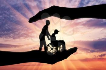 Silhouette of sad disabled man in wheelchair with nurse. The concept of care and care for people with disabilities in depression