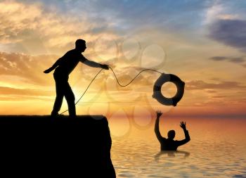 A silhouette of a man throws a lifeline to another man who is drowning in the water. The concept of mutual aid