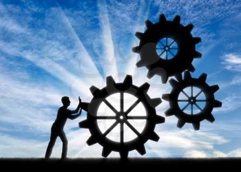 Silhouette of a businessman fixing a mechanism of gears. Establishment of business concept
