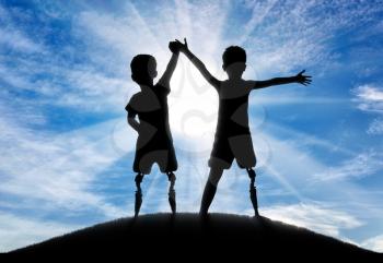 Children with disabilities. Two boys of a disabled person with a prosthetic leg standing, holding hands, on top of a hill